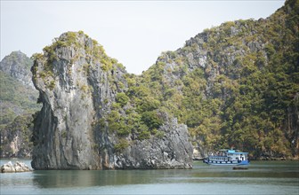 Excursion boat travelling between the karst rocks in Lan Ha Bay, Halong Bay, Vietnam, Asia