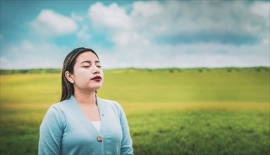 Close up of relaxed woman breathing fresh air in the field. Relaxed girl breathing fresh air in the