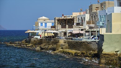 Picturesque coastal village with houses and balconies on the blue water, sunny atmosphere,