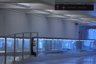 Modern airport terminal with blue illuminated walkway, handrails and minimalist design, Toronto