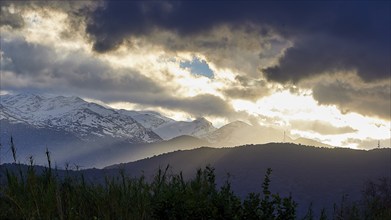 Sunset over mountains with dramatic sky and silhouettes in the foreground, Lefka Ori, White