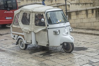 Three-wheeled scooter Ape by Piaggio in a street in Matera, Basilicata, Southern Italy, Italy,