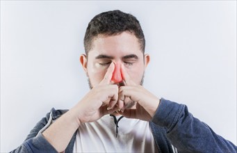 Sore person suffering with nasal bridge on isolated background. Suffering man with nasal congestion