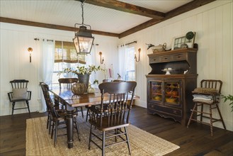 Brown stained pine wood antique reproduction style dining table with high back chairs in dining