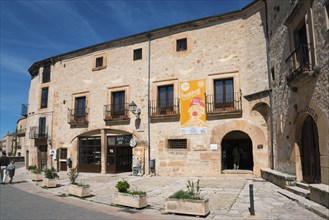 Stone building with information posters and old windows on a sunny street, former prison, museum,