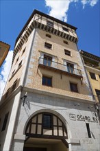 High, antique building complex designed with stone, has balconies and large windows, Toledo,