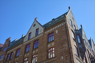 Row of historic Hanseatic houses with striking facades under a clear blue sky, Bryggen, Bergen,