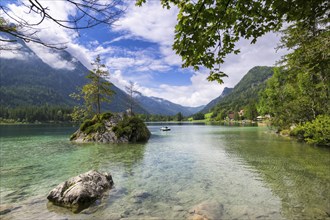 Hintersee near Ramsau with clear green water, surrounded by forests and mountains under a cloudy