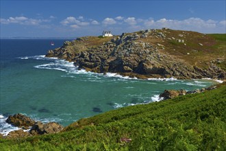 Lighthouse house Phare du Millier on cliff overlooking the sea under a clear sky, Point du Millier,