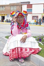 Peruvian woman, 20 years old, in traditional dress at the market in Cocotos on Lake Titicaca, Puno