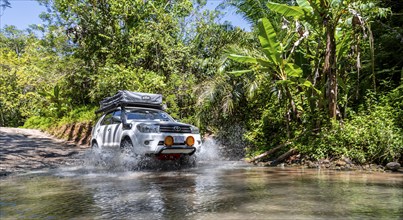 4x4 car drives through a river, water crossing with the off-road car, Costa Rica, Central America