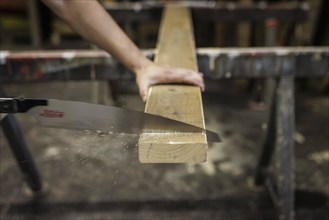 A man sawing wood with a Japanese handsaw, Kariwaku 333, Berlin, 14.08.2024