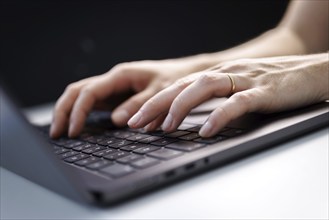 Hands typing on a laptop keyboard in Berlin, 09/08/2024