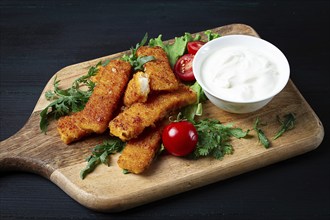 Fried fish nuggets, with white sauce, arugula and cherry, no people