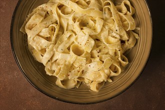 Fettuccine, tagliatelle, in creamy garlic sauce, Italian traditional cuisine, pasta carbonaro