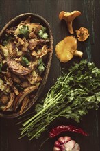 Fried chanterelles with mushrooms, in a clay pan, close-up, top view, selective focus