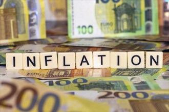 Symbolic image of inflation: euro banknotes and letter cubes showing the word inflation