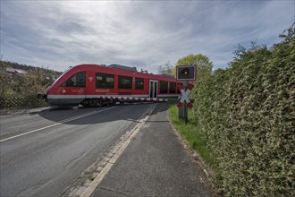 A regional train crosses a level crossing with a barrier, Schnaittach, Middle Franconia, Bavaria,