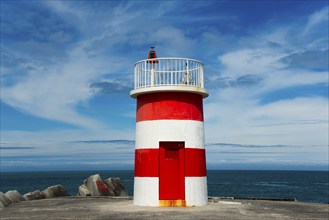 A red and white lighthouse at the sea under a blue sky with white clouds, lighthouse, Porto de