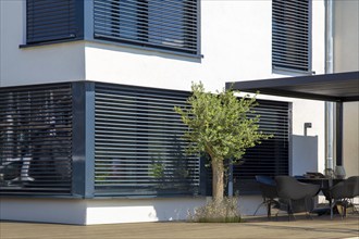 Modern blinds on a sliding window with access to the garden terrace