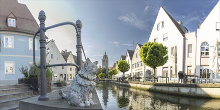 Bronze sculpture by Cornelia Brader: City tomcat Chicco at the city stream, behind it Our Lady's