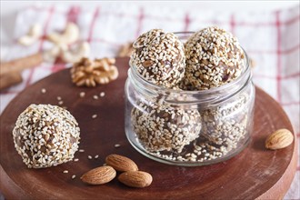 Energy balls cakes with almonds, sesame, cashew, walnuts, dates and germinated wheat on wooden