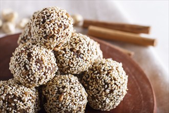 Energy balls cakes with almonds, sesame, cashew, walnuts, dates and germinated wheat on wooden