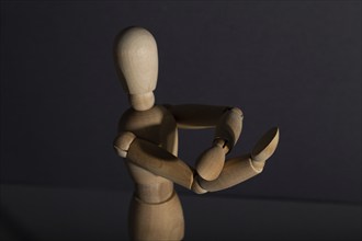 Wooden mannequin shows obscene gesture fuck off with hands on gray background. protest, riot,