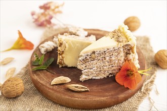 Walnut and almond cake on white wooden background and linen textile. side view, close up, selective