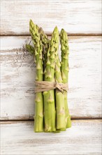 Bunch of fresh green asparagus on white wooden background. Top view, flat lay, close up. harvest,