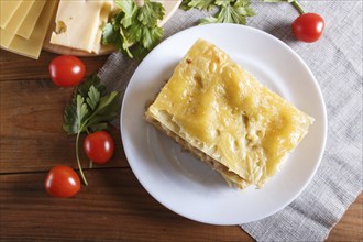 Lasagna with minced meat and cheese on brown wooden background. close up, top view