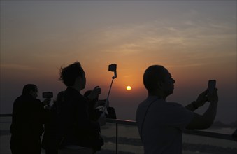 Tourists take selfie with smartphone, selfie stick, The View At the Palm, Palm Jumeirah, sunset,