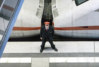 A Deutsche Bahn service employee stands in front of an ICE train on the platform at Berlin Central