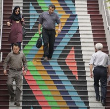 People walk down a painted staircase. The city of Tehran is changing the image of the city through