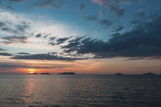 Beautiful purple sunset on the sea with small islands on the horizon