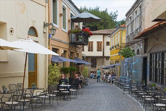 Cosy street café with guests and parasols on an old cobbled street, Xanthi, Eastern Macedonia and