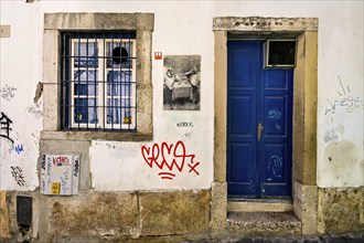 Graffiti and street art on weathered walls of an old building at nighttime, Alfama, Lisbon