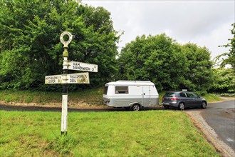 Old moss-covered signposts in the countryside, showing direction and distance to Ham, Sandwich and