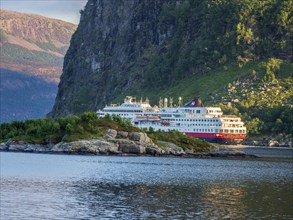 Ship of Hurtigruten passes Hornelen mountain, steep cliff, famous hiking destination, Bremanger,