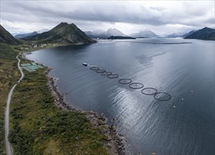 Aerial view of a salmon farm, rainy weather, grey sky, village Myre in the back, Vesteralen