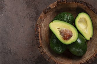 Fresh, sliced avocado, in a wooden plate, top view, food background, concept, food styling