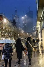 Rainy weather, freezing rain, pedestrian zone Zeil, shopping street, high-rise skyline in clouds,