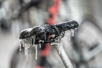 Freezing rain, icy saddle of a rental bike, after freezing rain, in the city centre of Frankfurt,