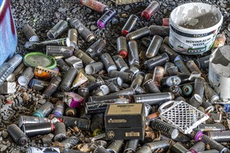 Empty spray paint cans, on a railway line below a road bridge, thrown away, disposed of by the