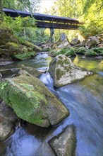 The Irrel Waterfalls, rapids in the lower reaches of the Prüm, covered wooden bridge for hikers,