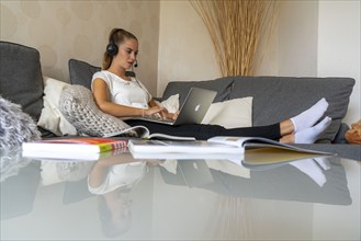 Young student learns at home, online, in conversation with other students