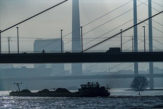 Dense fog slowly lifting, cargo ships on the Rhine near Düsseldorf, in front the Oberkassler