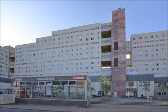 Modern red high-rise building with inner courtyard, inscription, multi-storey car park, cash desk,