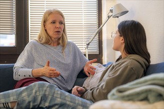 Mother and daughter, teenage, 13 years old, in a confidential conversation, at home