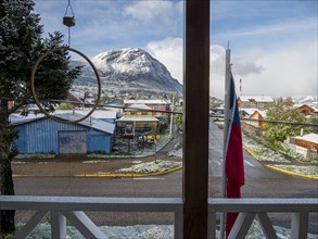 View out of a hotel to streets of Coyhaique, snow covered mountain Mt. Mackay, Patagonia, Chile,